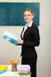 Photo: Portrait of teacher woman near chalkboard in classroom Portrait of teacher woman near chalkboard in classroom