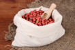 Peanuts in sack on wooden background