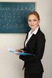 Portrait of teacher woman near the chalkboard in classroom