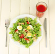 Caesar salad on white plate, on color wooden background