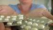 A female hand holding a packs of pills.