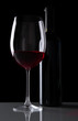 Glass of wine with bottle on black background