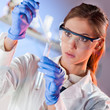 Attractive young scientist pipetting.