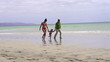 Happy family walking on the beach