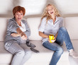 Foto: Mother with adult daughter watching television Mother with adult daughter watching television