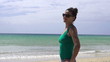 Happy woman standing on the beach, super slow motion