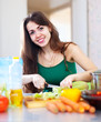  Happy  woman cutting vegetables