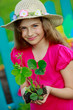 Gardening- lovely girl with strawberry seedling in the garden