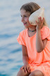 Lovely girl with shell at the beach