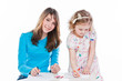 two beautiful girls draw with pencils