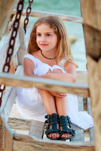 Photo: Lovely girl on bench in the beach resort Lovely girl on bench in the beach resort