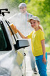 Carwash - young girl helping father to wash car.
