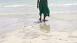 Woman in green dress walking on the beach