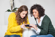 Photo: Two Beautiful Women with Mobile Phone in the Living Room Two Beautiful Women with Mobile Phone in the Living Room