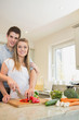 Happy couple preparing vegetables