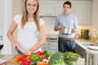Woman preparing vegetables with man helping