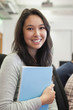 Student in a computer room holding a folder
