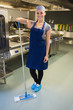 Smiling woman cleaning the kitchen floor