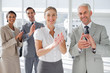 Smiling business people applauding together