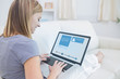 Photo: Woman sitting on sofa and checking her social media profile Woman sitting on sofa and checking her social media profile