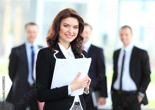 Photo: Face of beautiful woman on the background of business people Face of beautiful woman on the background of business people