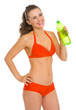 Smiling young woman in swimsuit with bottle of water