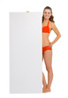 Happy young woman in swimsuit showing blank billboard