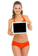 Smiling young woman in swimsuit showing blank billboard
