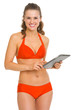 Smiling young woman in swimsuit showing blank billboard