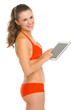 Smiling young woman in swimsuit showing blank billboard