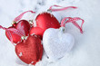 Red and white heart ornaments in snow