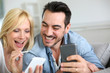 Cheerful couple having fun using smartphone