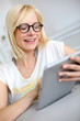 Photo: Blond girl websurfing with tablet Blond girl websurfing with tablet