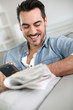 Photo: Man relaxing at home with newspaper Man relaxing at home with newspaper