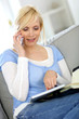 Photo: Woman on the phone checking agenda Woman on the phone checking agenda