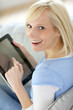Smiling woman using tablet in sofa