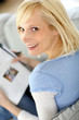 Photo: Smiling blond woman reading magazine Smiling blond woman reading magazine