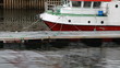Small Norwegian fishing boat moored under the rain