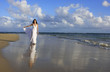 Young woman in white dress on a beach