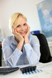Photo: Businesswoman at desk with hands on chin Businesswoman at desk with hands on chin