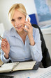 Businesswoman on the phone writing on agenda