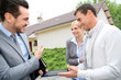 Real-estate-agent showing house plan on digital tablet
