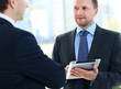 Business partners working in hallway with electronic tablet