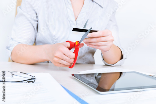 Photo: Businesswoman cutting credit card Businesswoman cutting credit card