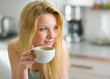 Portrait of happy young woman drinking coffee in the morning