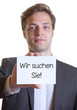 Junger Mann im Anzug mit Karte WIR SUCHEN SIE!