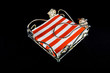 Napkin holder with red and white napkin over black background