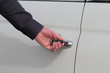 Weisse Autotür wird mit Schlüssel geöffnet