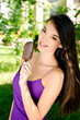 Woman eating a delicious chocolate ice cream in the park