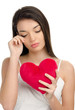 Girl crying and holding a red heart. Concept of unhappy love